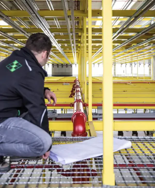 Brandschutz-Ingenieure mit Plänen und Modellen auf einem Tisch